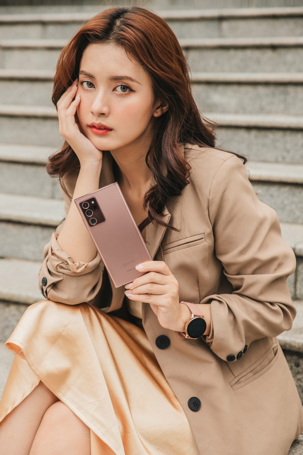 woman in brown coat holding white box